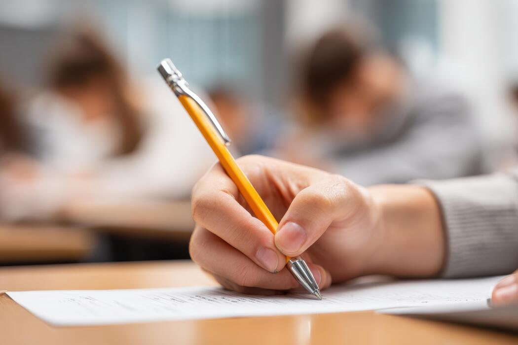 child writes an essay with a pen 